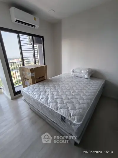Spacious bedroom with large window and air conditioning, featuring a new mattress and scenic view.