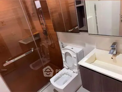 Modern bathroom with glass shower and sleek fixtures in contemporary apartment.