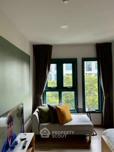 Cozy living room with modern decor and natural light from large windows.