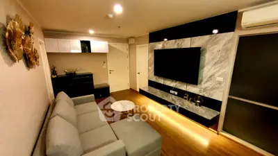 Modern living room with stylish decor and large wall-mounted TV