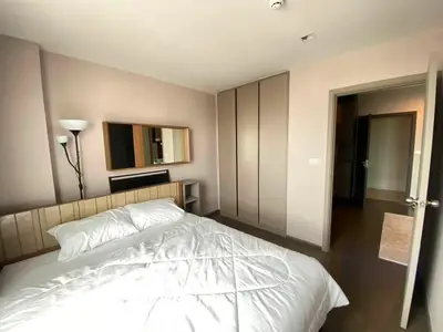 Modern bedroom with stylish decor and ample natural light, featuring a cozy bed and sleek built-in wardrobe.
