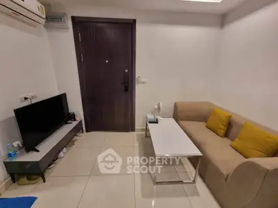 Cozy living room with modern sofa, TV, and air conditioning in a stylish apartment.