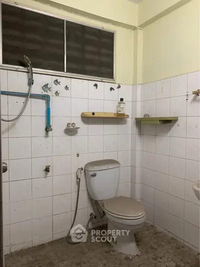 Cozy bathroom with tiled walls and essential fixtures, ideal for compact living spaces.