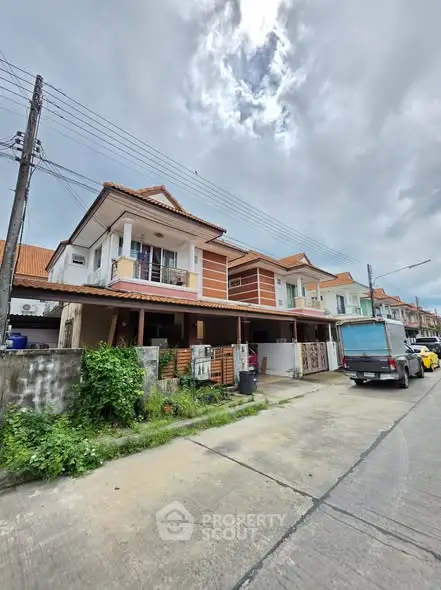 Charming suburban townhouse with red-tiled roof and spacious driveway, perfect for family living.
