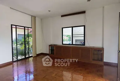 Spacious living room with wooden flooring and large windows in a modern home.