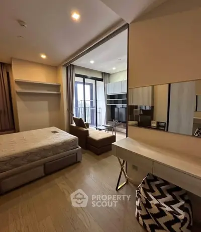 Modern studio apartment with open layout, featuring a cozy living area and a spacious balcony.