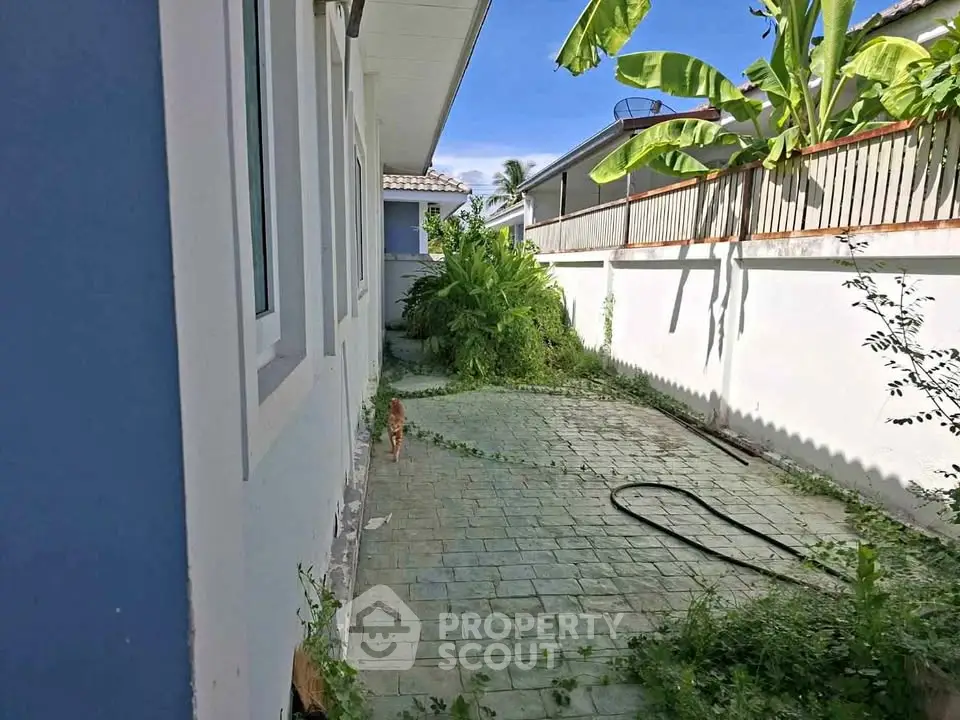 Charming backyard with lush greenery and paved patio in a serene residential area.