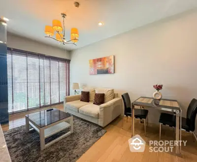 Modern living room with cozy sofa, stylish decor, and dining area in open layout apartment.