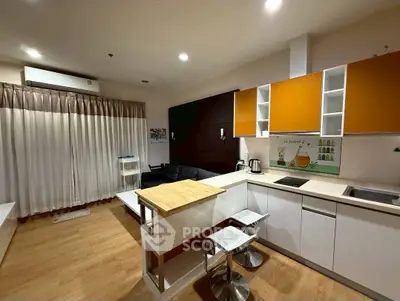 Modern open-layout kitchen with stylish orange cabinets and cozy living area