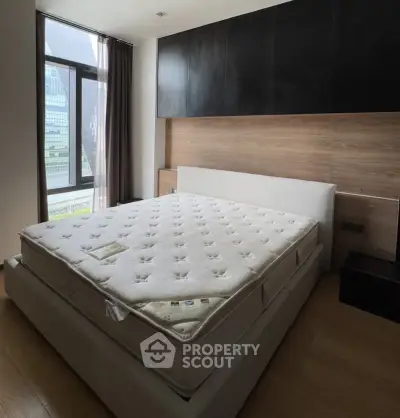 Spacious bedroom with modern design and large window offering city views
