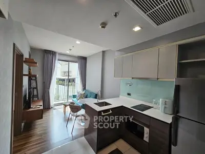 Modern open-layout kitchen and living area with sleek design and balcony view.
