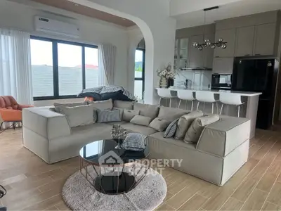 Spacious modern living room with stylish furniture and open kitchen layout, perfect for entertaining.