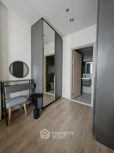 Modern bedroom with stylish furniture and ensuite bathroom in a contemporary apartment.