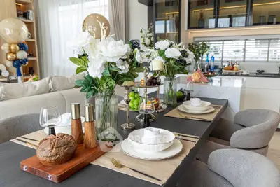 Luxurious dining area with elegant table setting and modern kitchen in background.