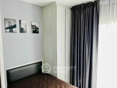Cozy bedroom with modern decor and large window for natural light.