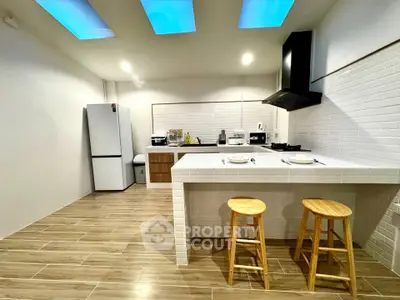 Modern kitchen with open layout, featuring sleek appliances and stylish bar seating.
