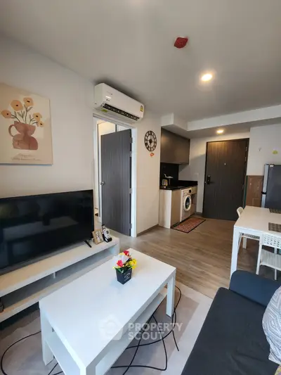 Modern living room with open kitchen, featuring stylish decor and appliances, perfect for urban living.