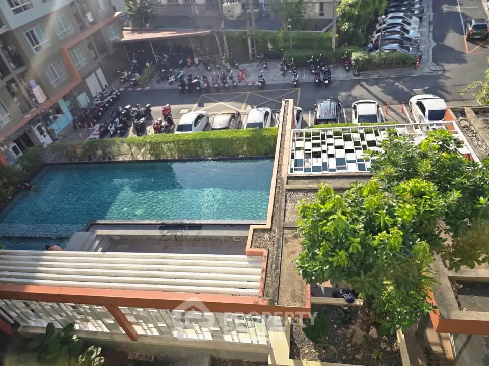 Stunning aerial view of modern apartment complex with pool and lush greenery, perfect for urban living.