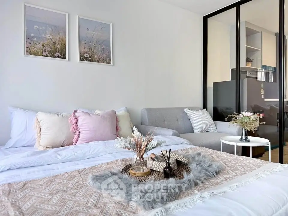 Cozy bedroom with stylish decor and natural light, featuring a comfortable bed and modern furnishings.