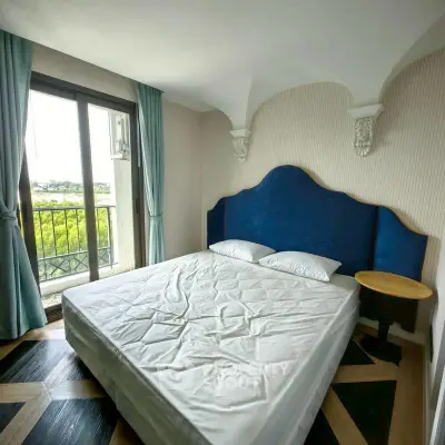 Elegant bedroom with large window and stylish blue headboard