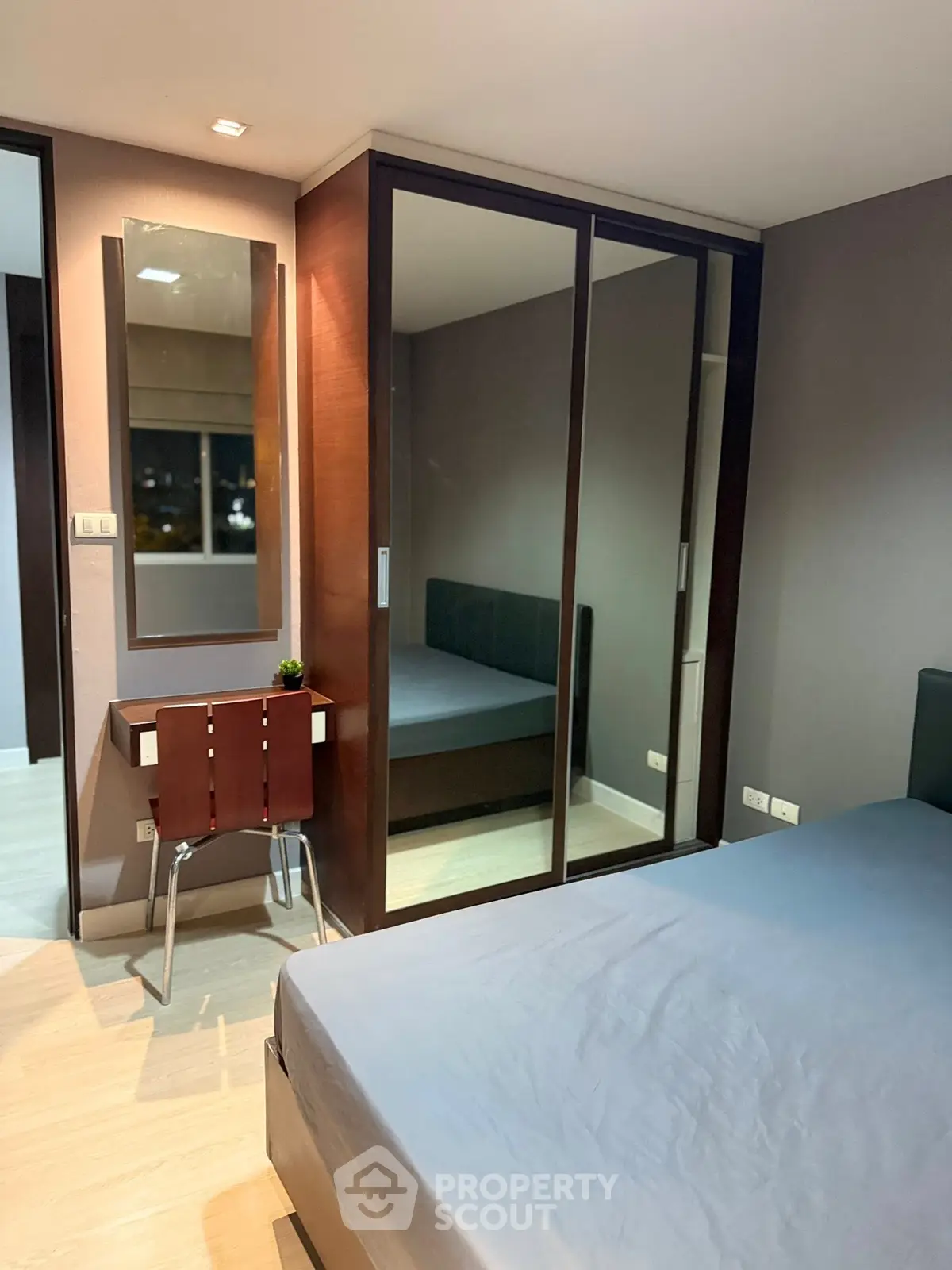 Modern bedroom with mirrored wardrobe and sleek furniture design