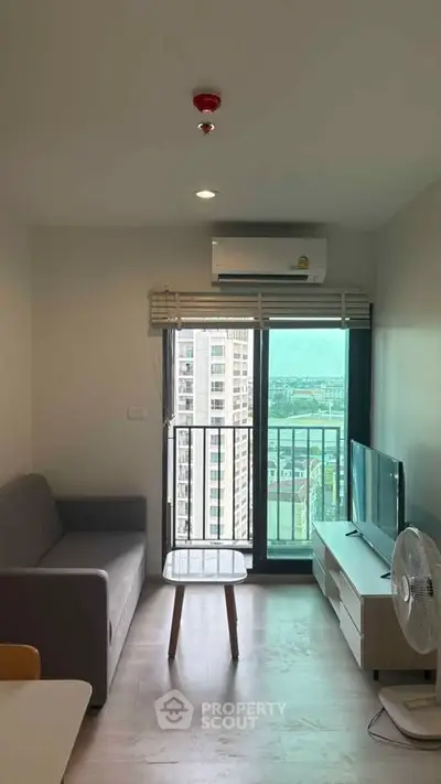 Modern living room with city view, featuring sleek furniture and air conditioning, ideal for urban living.