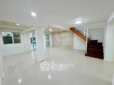 Spacious modern living room with staircase and large windows