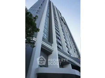 Modern high-rise building exterior with sleek architectural design and large windows.