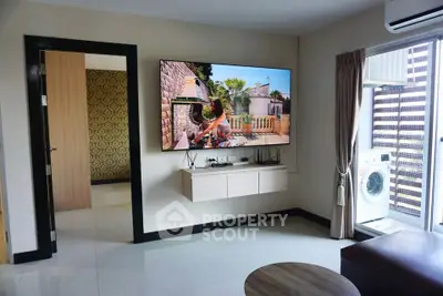 Modern living room with wall-mounted TV and washing machine on balcony