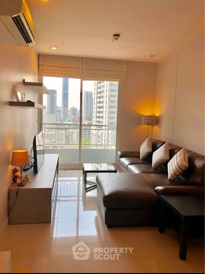 Modern living room with city view, featuring sleek furniture and ambient lighting.