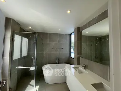 Luxurious modern bathroom with freestanding tub and glass shower enclosure