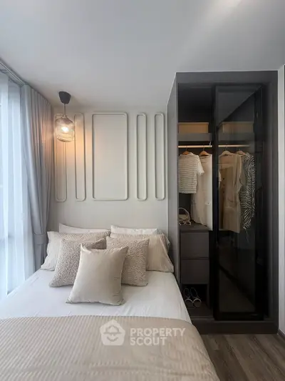 Modern bedroom with stylish decor and built-in closet, featuring elegant lighting and cozy bedding.