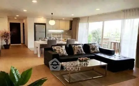 Spacious open-plan living room with modern kitchen and large balcony access.