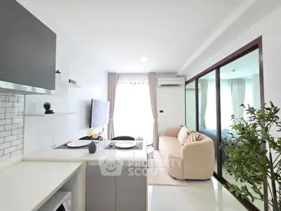 Modern open-layout living room with sleek kitchen and cozy seating area, perfect for urban living.