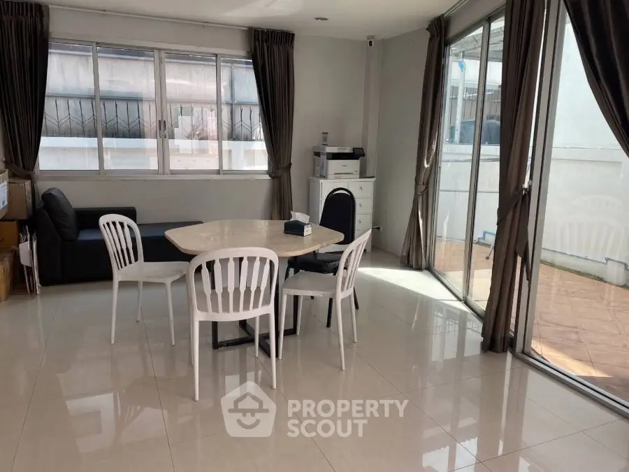 Bright dining area with large windows and modern furniture in a spacious room.