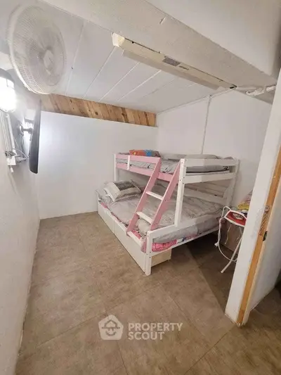 Compact bedroom with white walls and a bunk bed, ideal for maximizing space in a small apartment or dormitory setting.