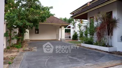 Charming residential driveway with lush greenery and spacious carport