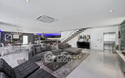 Luxurious open-plan living room with modern decor and elegant staircase