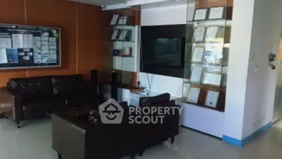 Modern office lounge with leather seating and wall-mounted TV