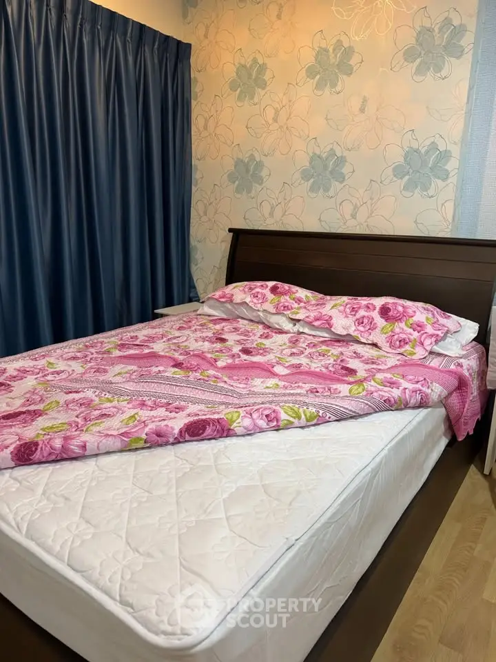 Cozy bedroom with floral bedding and elegant wallpaper, perfect for a restful retreat.