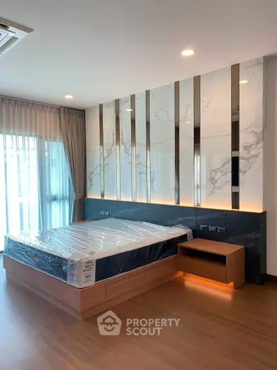 Luxurious modern bedroom with stylish marble accent wall and natural light