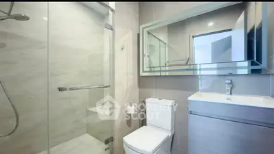 Modern bathroom with glass shower and sleek fixtures in contemporary apartment.