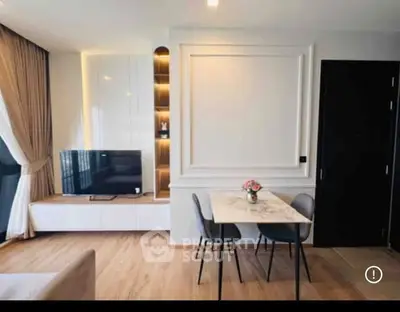 Modern living room with stylish decor and dining area, featuring a sleek TV unit and elegant lighting.
