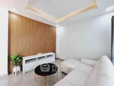 Modern living room with sleek white sofa and stylish wooden accent wall