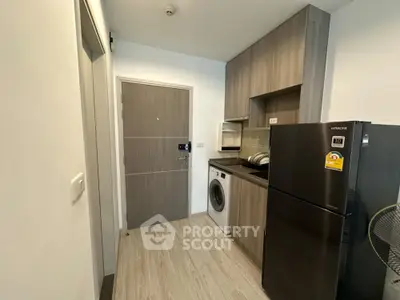 Modern compact kitchen with washing machine and fridge in stylish apartment