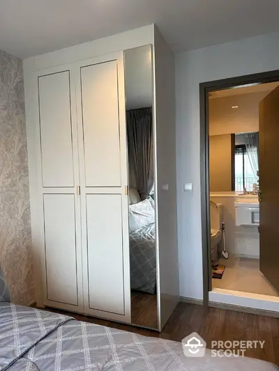 Modern bedroom with mirrored wardrobe and ensuite bathroom