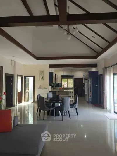 Spacious open-layout living and dining area with modern kitchen and high ceilings.