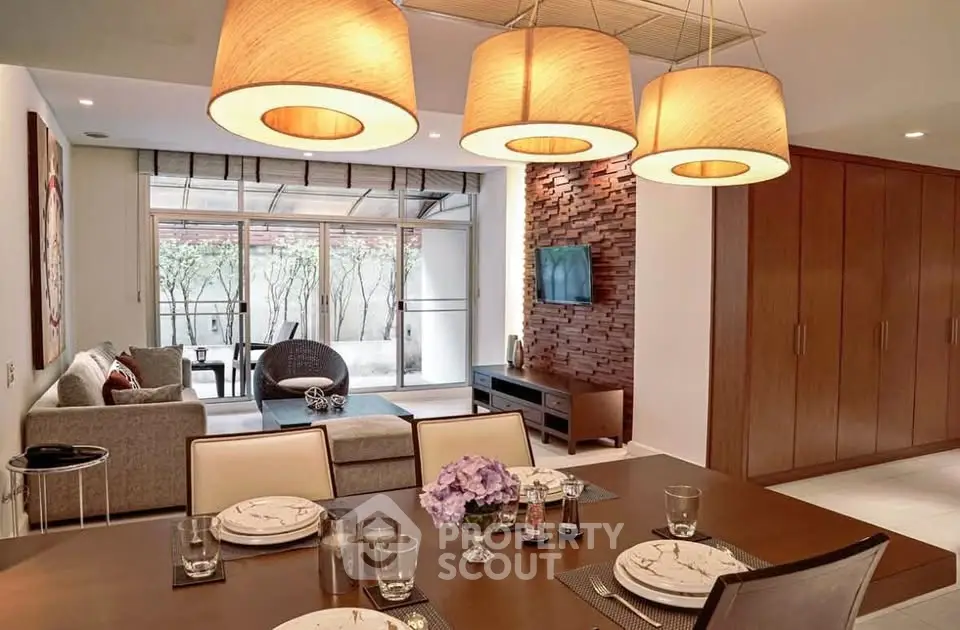 Elegant living and dining area with modern decor and large windows in a stylish apartment.