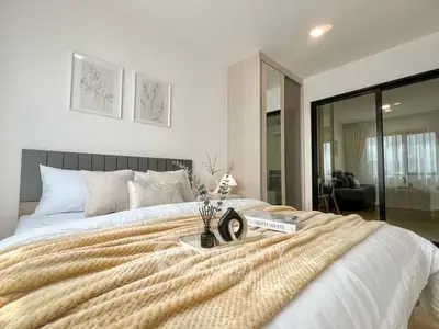 Luxurious bedroom with cozy bedding and elegant decor in modern apartment.