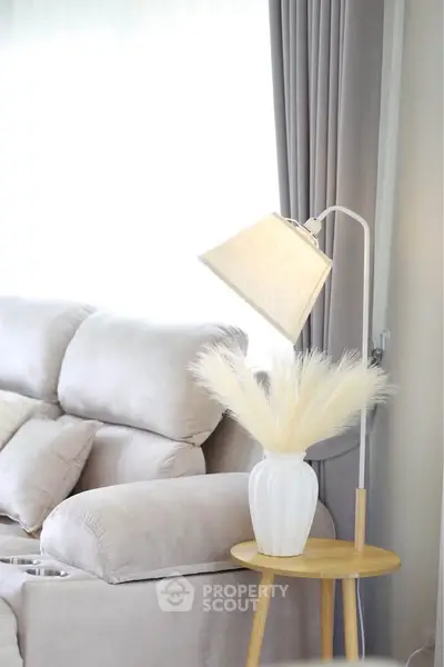 Elegant living room with plush sofa, stylish lamp, and decorative vase on side table.